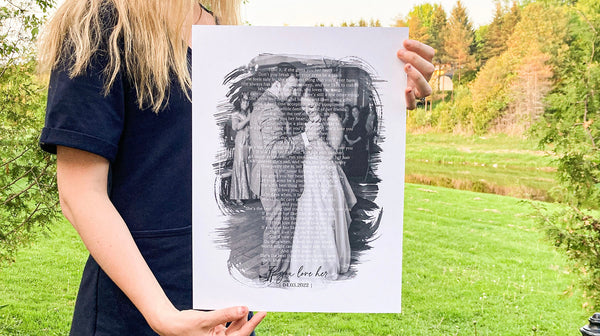 Girl holding wedding print standing in front of river