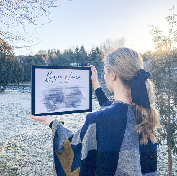 girl holding frame with wedding vow art