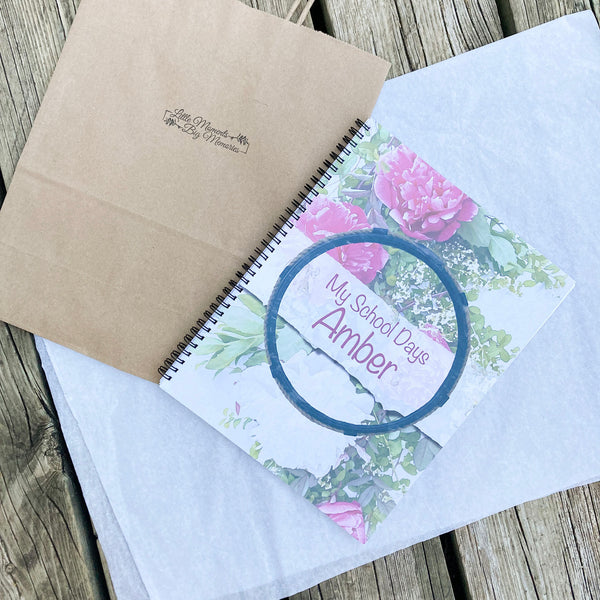 Pink peonies school memory book lying on paper bag and white tissue paper